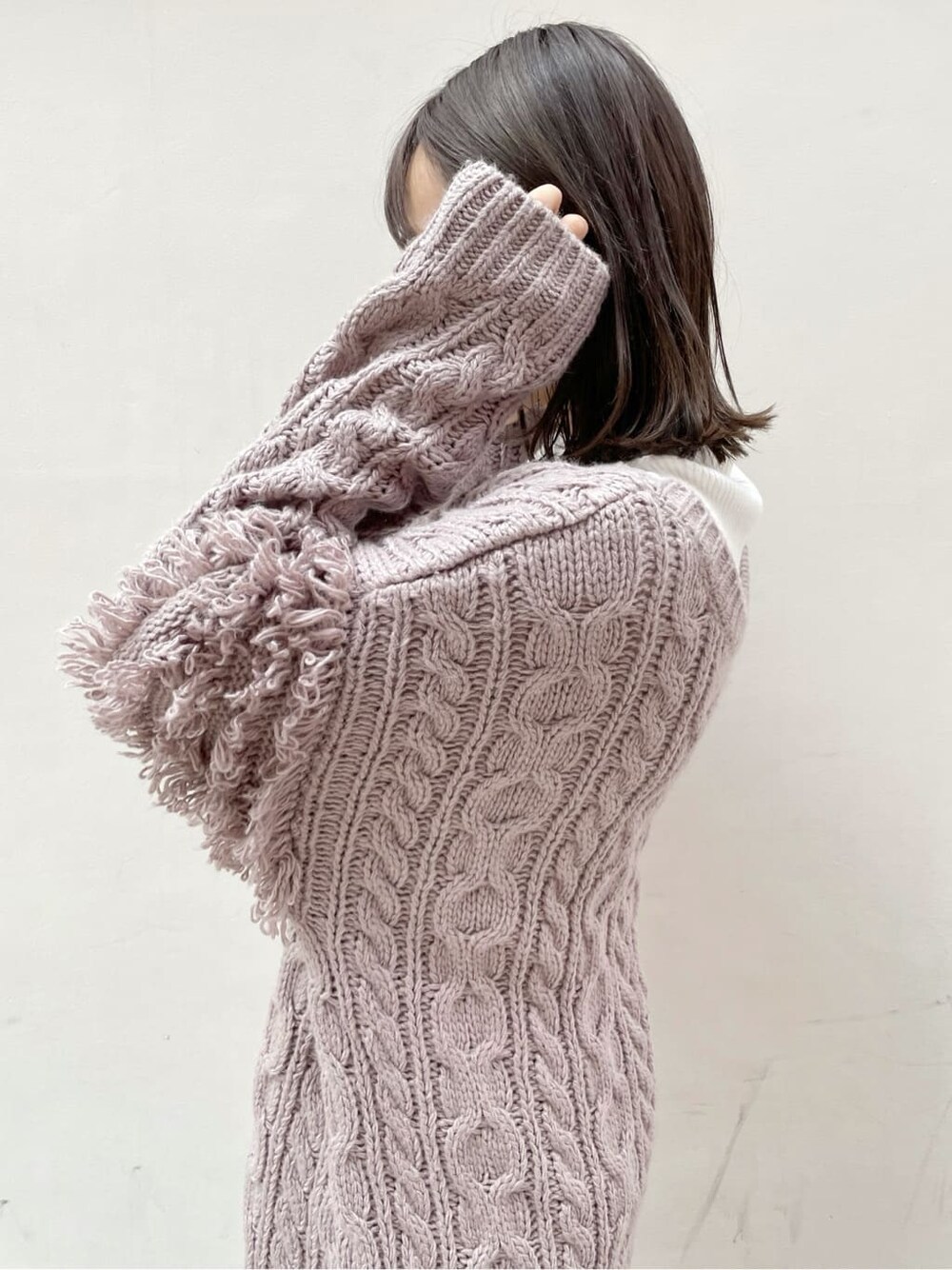 ブラウン系のスカート、ベージュ系のブーツ、ホワイト系のニット/セーターを着用したレディースの秋コーディネートの6枚目の写真