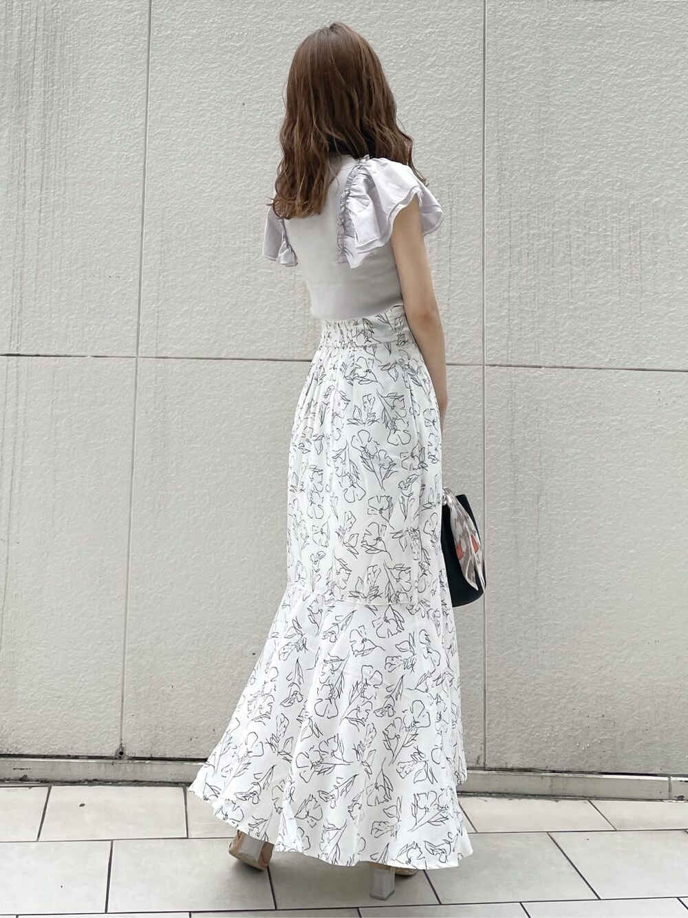 その他のサンダル、ホワイト系のスカート、ブラック系のハンドバッグを着用したレディースの夏コーディネートの3枚目の写真