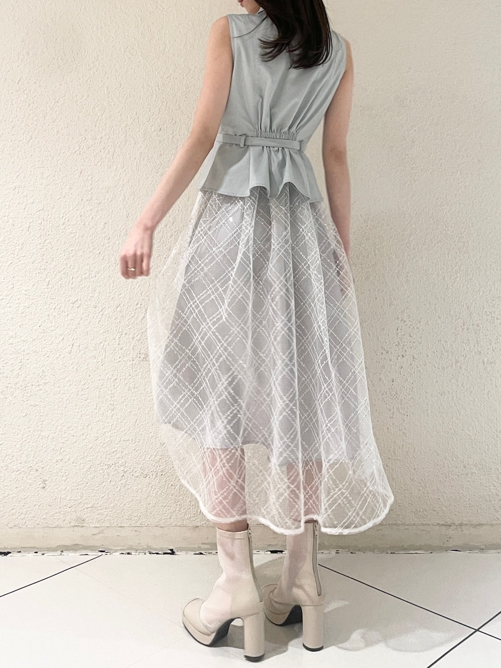 ブルー系のワンピース、ホワイト系のブーツを着用したレディースの冬コーディネートの3枚目の写真