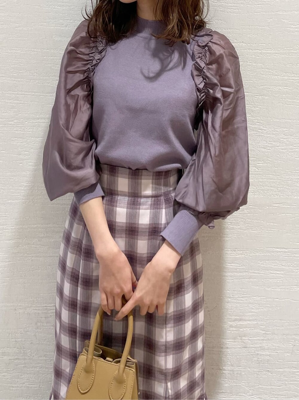 パープル系のスカート、ベージュ系のブーツ、パープル系のニット/セーターを着用したレディースの冬コーディネートの4枚目の写真