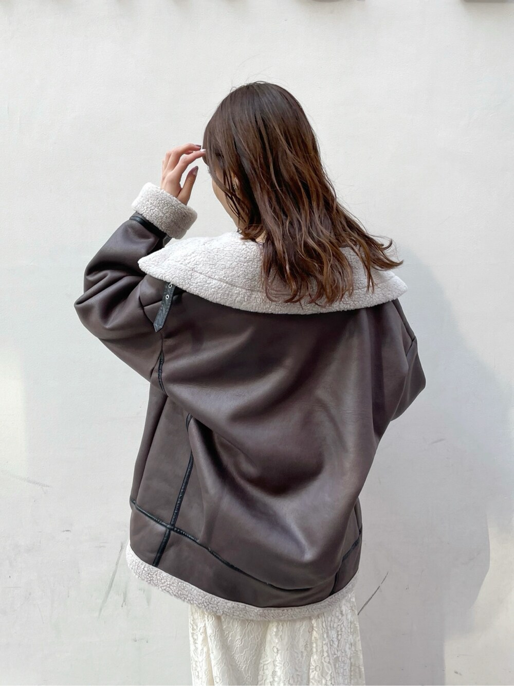 パープル系のニット/セーター、ホワイト系のブーツ、ホワイト系のスカートを着用したレディースの冬コーディネートの5枚目の写真