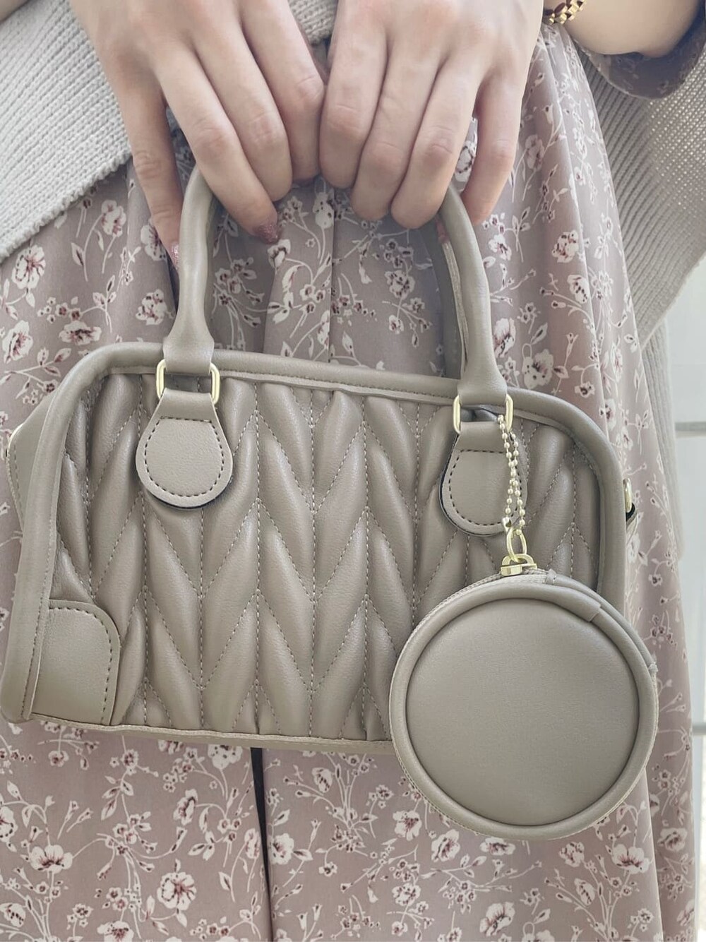 ピンク系のワンピース、ベージュ系のニット/セーター、ベージュ系のハンドバッグを着用したレディースの秋コーディネートの9枚目の写真