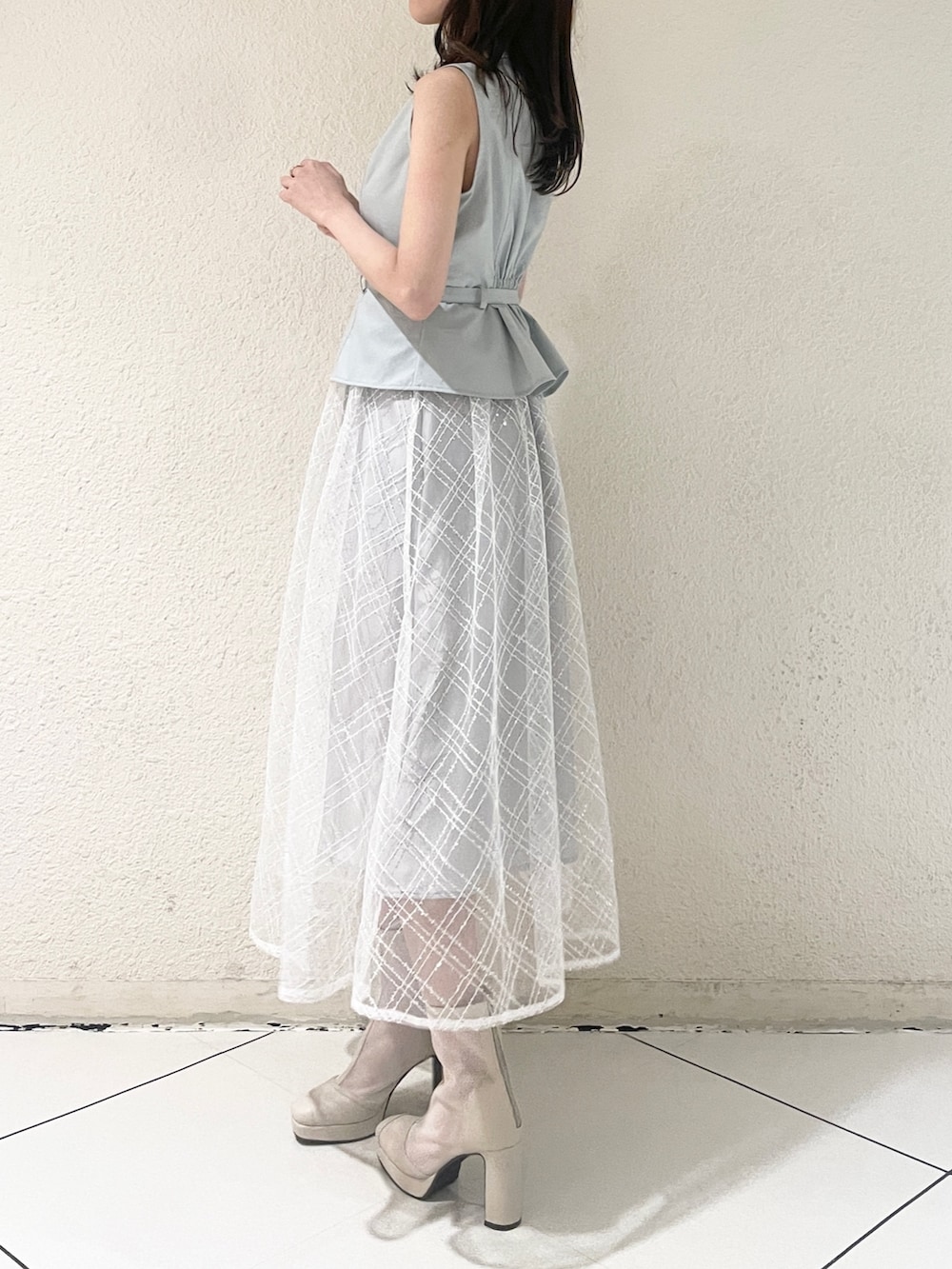 ブルー系のワンピース、ホワイト系のブーツを着用したレディースの冬コーディネートの4枚目の写真