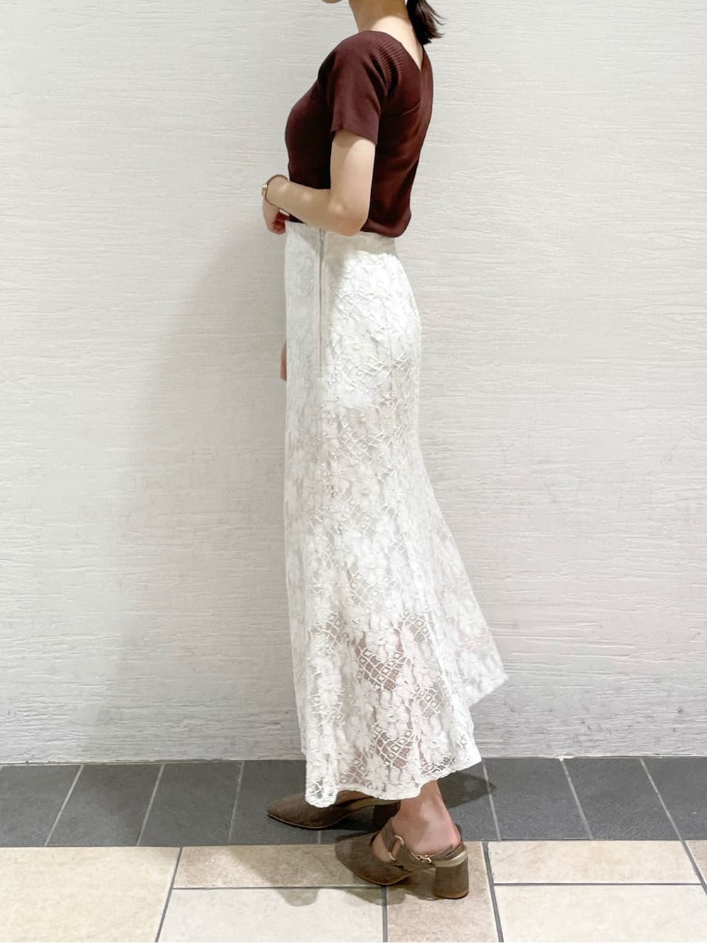 ホワイト系のスカート、ピンク系のダウンジャケット/コート、ブラウン系のニット/セーターを着用したレディースの夏コーディネートの8枚目の写真