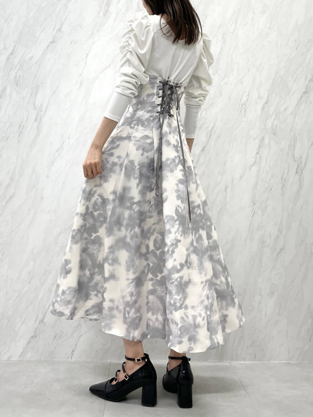 ホワイト系のワンピース、ブラック系のパンプスを着用したレディースの秋コーディネートの4枚目の写真