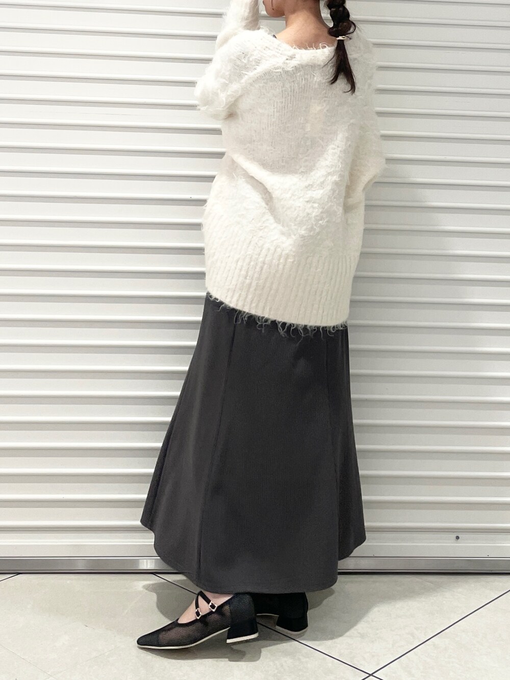 グレー系のワンピース、ブラック系のパンプス、ホワイト系のカーディガン/ボレロを着用したレディースの春コーディネートの5枚目の写真