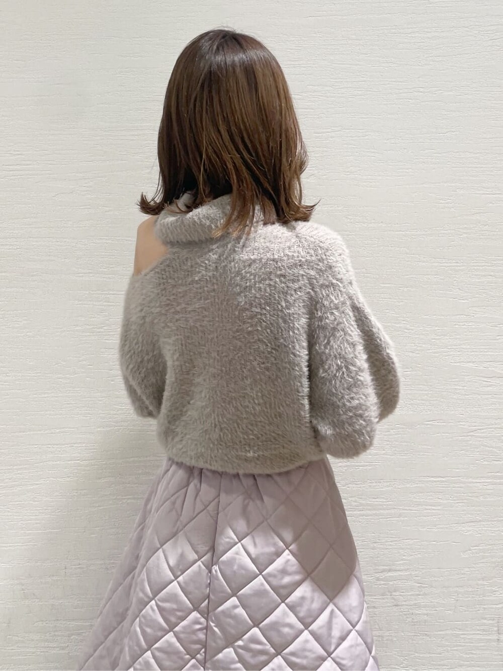 ピンク系のスカート、ブラック系のブーツ、ベージュ系のニット/セーターを着用したレディースの秋コーディネートの6枚目の写真