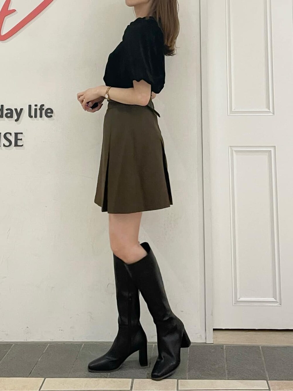 ブラウン系のスカート、ブラック系のブーツ、ブラック系のTシャツ/カットソーを着用したレディースの夏コーディネートの3枚目の写真