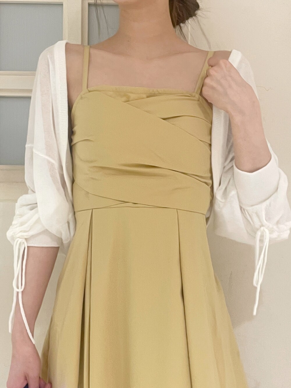 ホワイト系のカーディガン/ボレロ、イエロー系のワンピース、ホワイト系のハンドバッグを着用したレディースの夏コーディネートの5枚目の写真