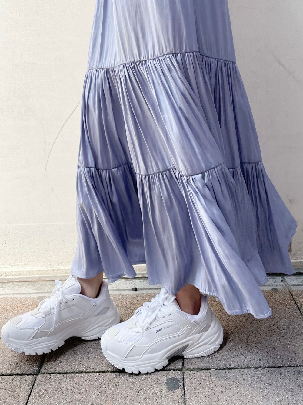 ブルー系のワンピース、ブルー系のスカート、ホワイト系のスニーカーを着用したレディースの春コーディネートの4枚目の写真