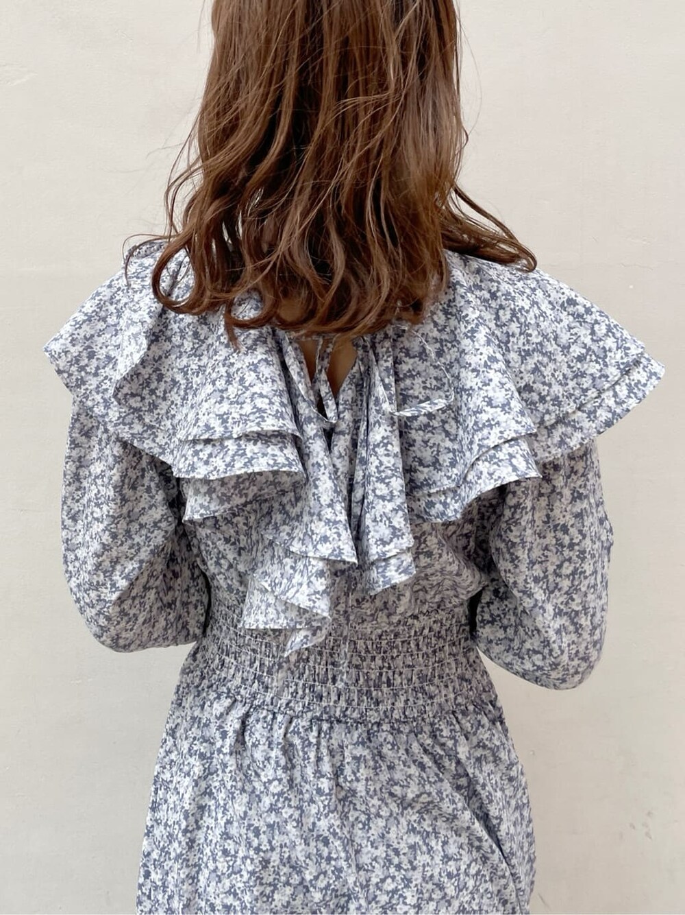 ベージュ系のトレンチコート、ブルー系のワンピース、ブラック系のブーツを着用したレディースの冬コーディネートの8枚目の写真