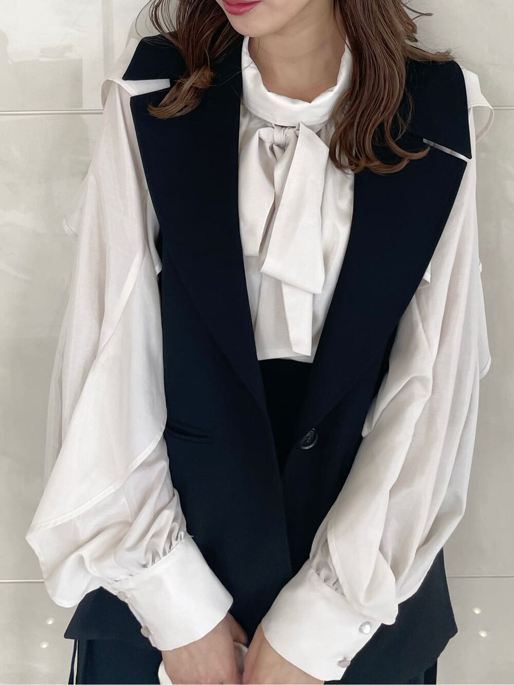 ホワイト系のシャツ/ブラウス、ブラック系のベスト、ブラック系のスカートを着用したレディースの秋コーディネートの5枚目の写真