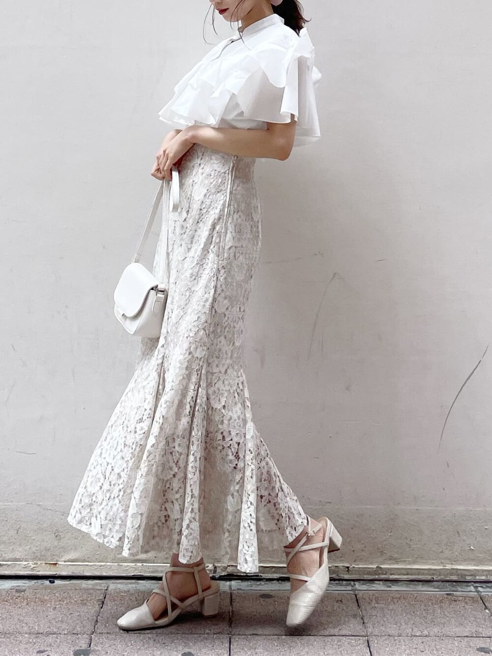 ホワイト系のパンプス、ホワイト系のショルダーバッグ、ホワイト系のシャツ/ブラウスを着用したレディースの春コーディネートの2枚目の写真