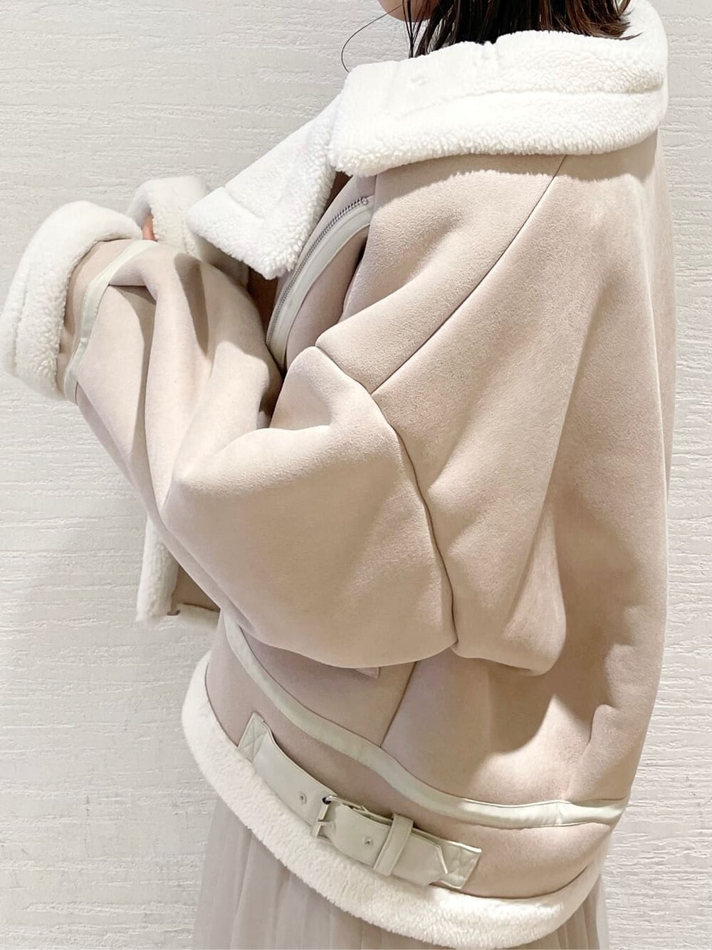 ベージュ系のスカート、ホワイト系のブルゾン、ブラウン系のニット/セーターを着用したレディースの夏コーディネートの5枚目の写真