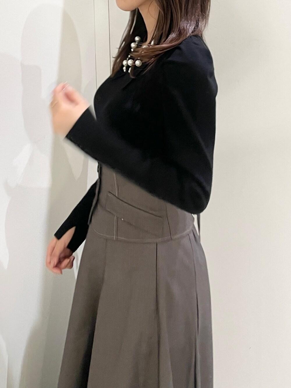 ブラック系のニット/セーター、ブラック系のローファー、グレー系のスカートを着用したレディースの秋コーディネートの5枚目の写真