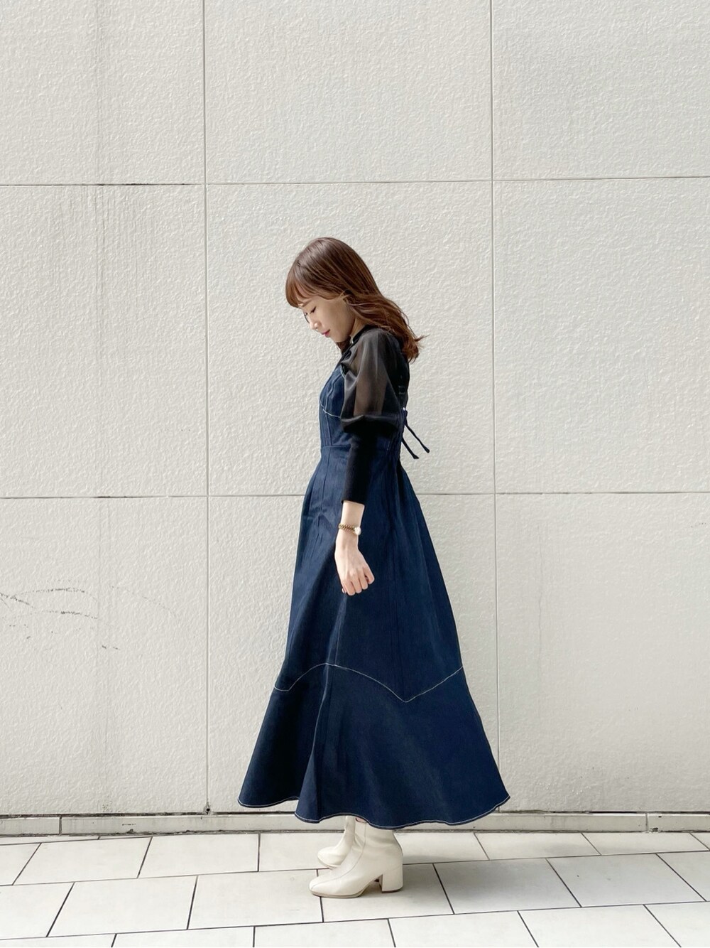 ホワイト系のブーツ、ブラック系のニット/セーター、ブルー系のワンピースを着用したレディースの冬コーディネートの6枚目の写真