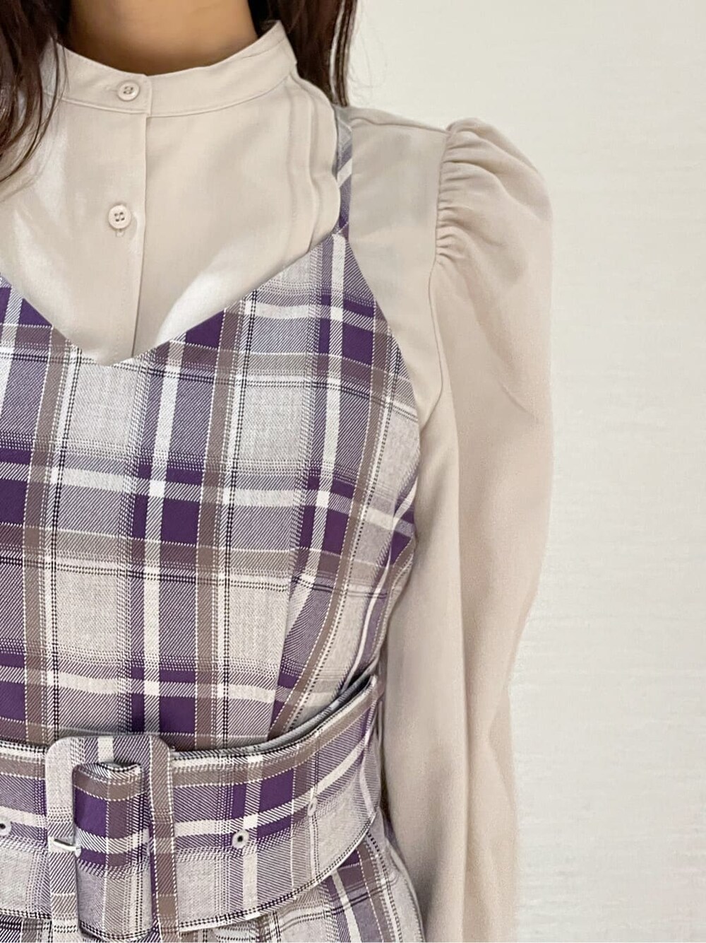 ブラック系のブーツ、ホワイト系のチェスターコート、パープル系のジャンパースカートを着用したレディースの冬コーディネートの9枚目の写真