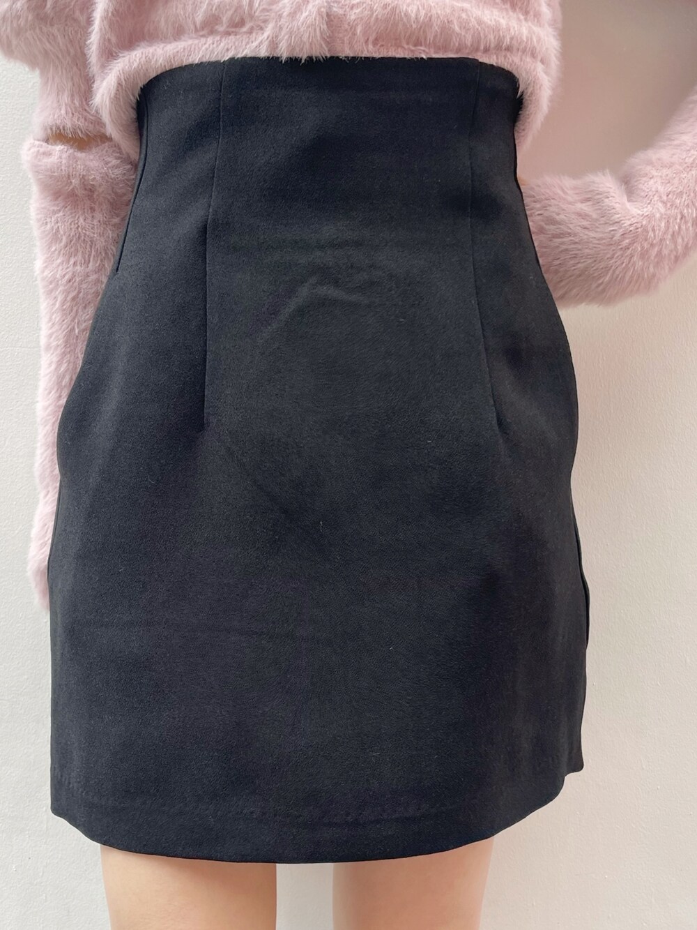 ピンク系のニット/セーター、ブラック系のスカート、ブラック系のブーツを着用したレディースの冬コーディネートの8枚目の写真