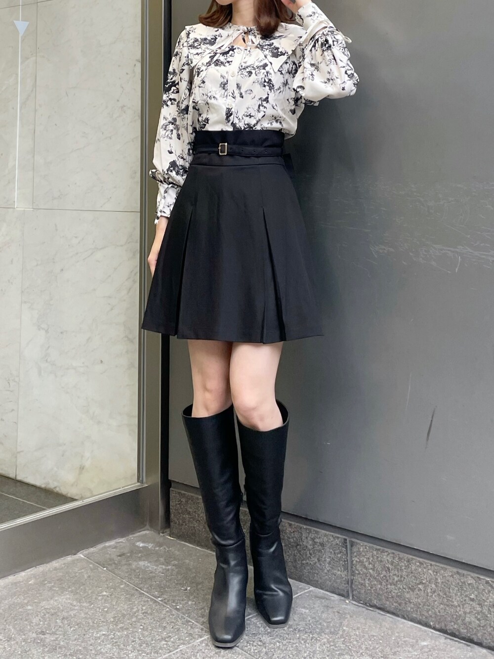 ホワイト系のシャツ/ブラウス、ブラック系のスカート、ブラック系のブーツを着用したレディースの冬コーディネートの3枚目の写真