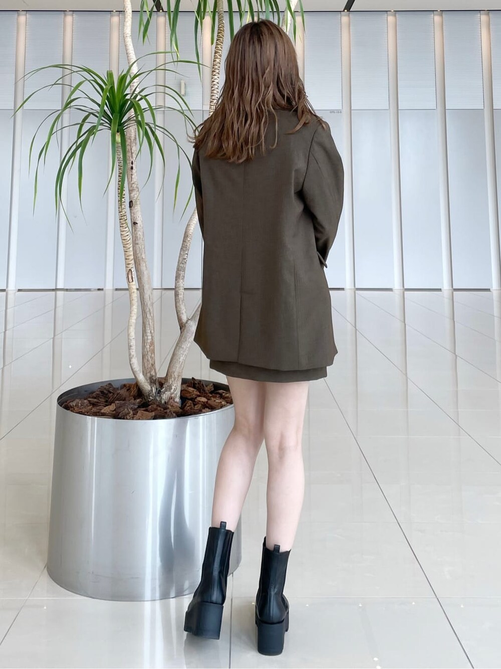 グリーン系のシャツ/ブラウス、ブラウン系のテーラードジャケット、ブラウン系のスカートを着用したレディースの秋コーディネートの3枚目の写真