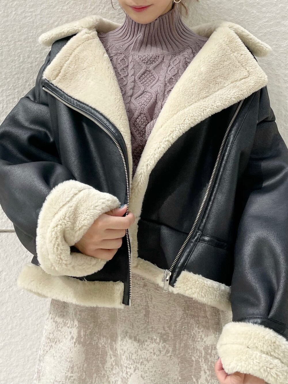 ブラック系のブルゾン、ベージュ系のスカート、ブラック系のブーツを着用したレディースの秋コーディネートの5枚目の写真