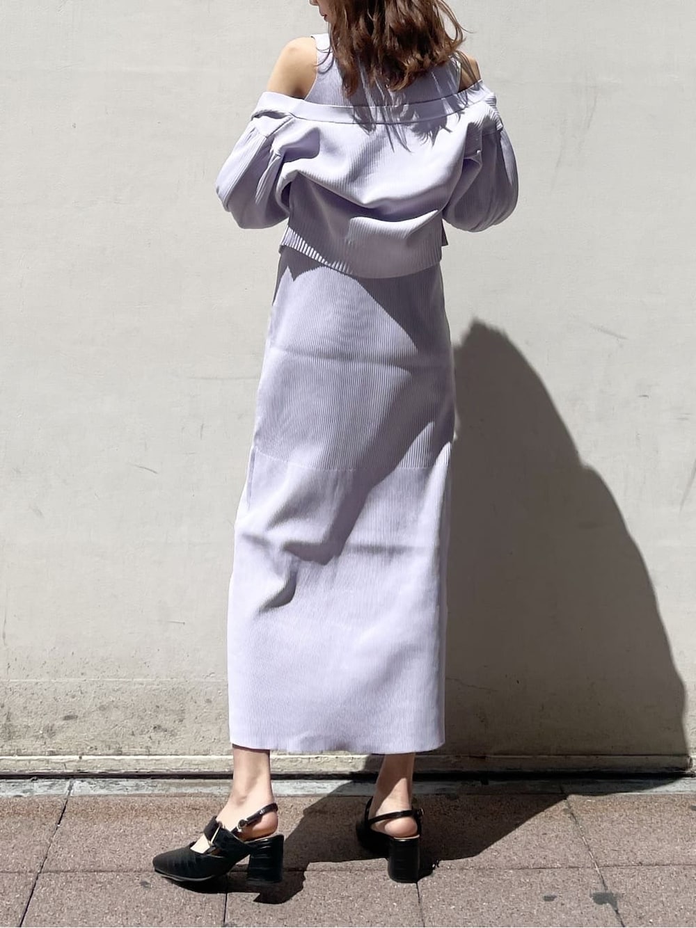 パープル系のワンピース、ブラック系のパンプス、ブラック系のハンドバッグを着用したレディースの春コーディネートの3枚目の写真