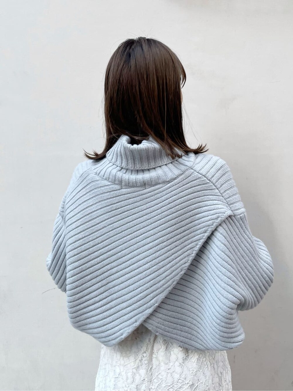 ホワイト系のスカート、ベージュ系のブーツ、ブルー系のニット/セーターを着用したレディースの秋コーディネートの6枚目の写真