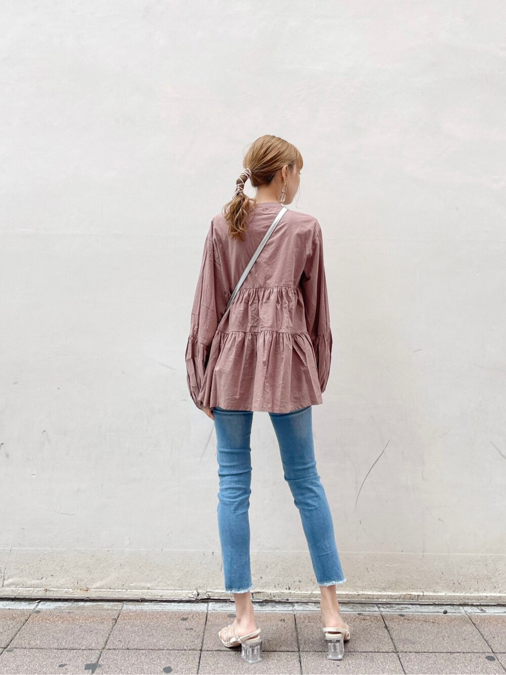 シルバー系のショルダーバッグ、ブルー系のデニムパンツ、ブラウン系のシャツ/ブラウスを着用したレディースの春コーディネートの2枚目の写真