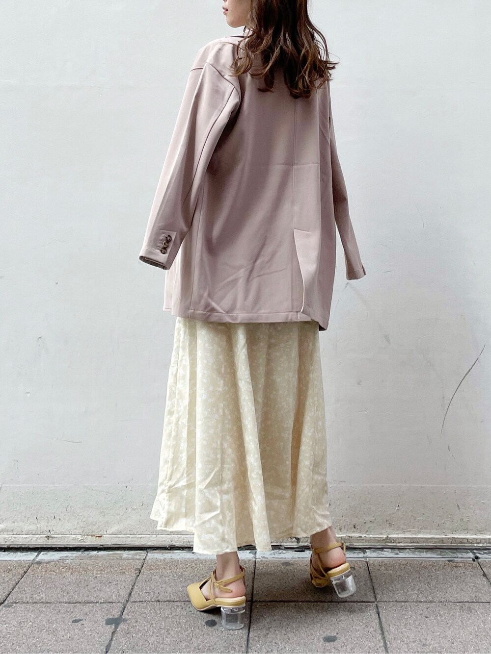 ベージュ系のテーラードジャケット、イエロー系のワンピース、イエロー系のパンプスを着用したレディースの春コーディネートの3枚目の写真