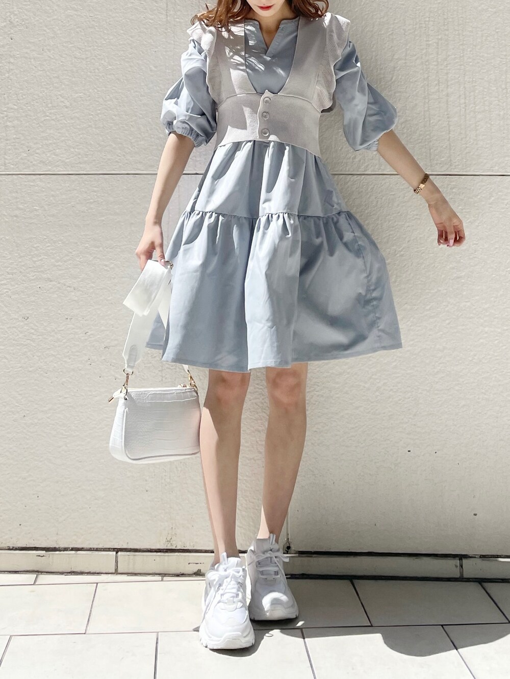 ホワイト系のスニーカー、ホワイト系のショルダーバッグ、ブルー系のチュニックを着用したレディースの春コーディネートの2枚目の写真