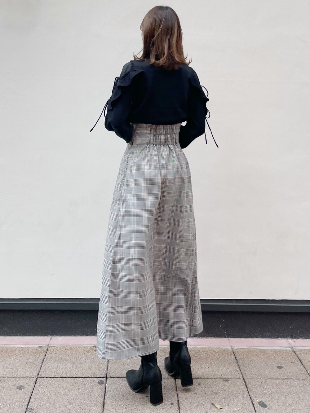 ブラック系のブーツ、ブラック系のニット/セーター、その他のスカートを着用したレディースの冬コーディネートの3枚目の写真