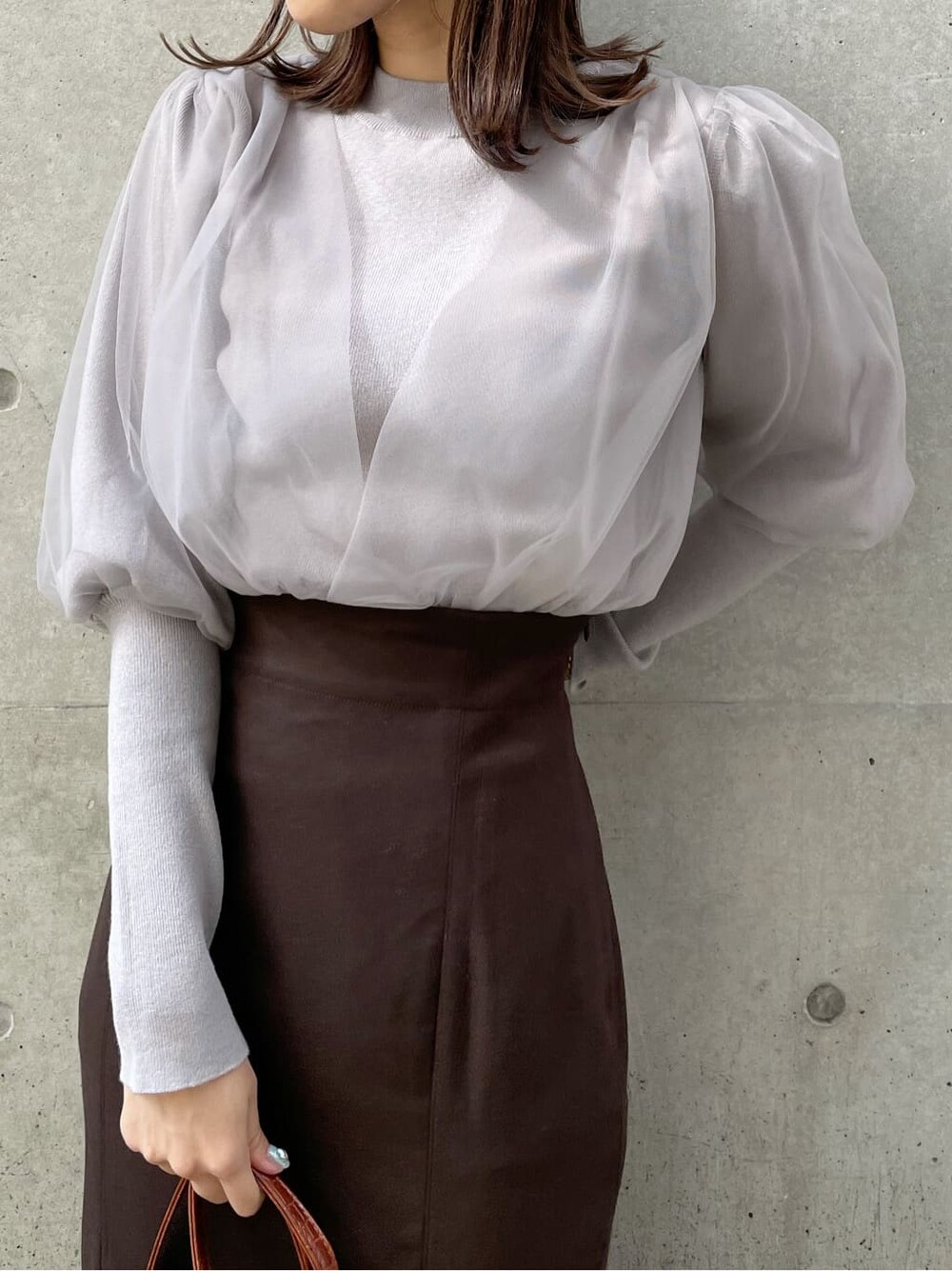 グレー系のニット/セーター、ブラック系のブーツ、ブラウン系のスカートを着用したレディースの秋コーディネートの4枚目の写真