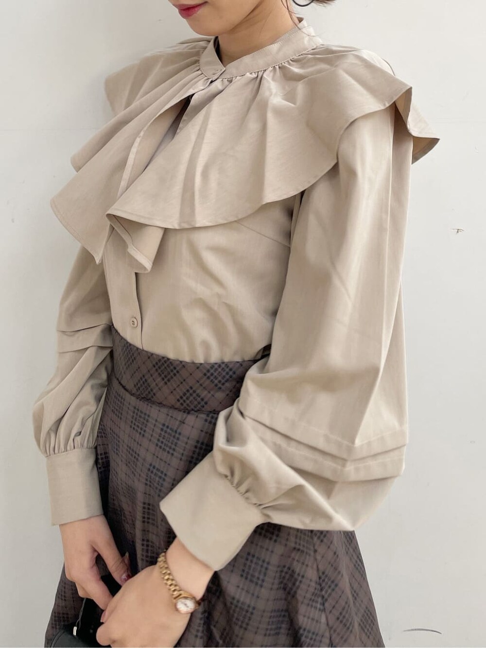 ブラック系のブーツ、ブラウン系のスカート、ベージュ系のシャツ/ブラウスを着用したレディースの冬コーディネートの6枚目の写真