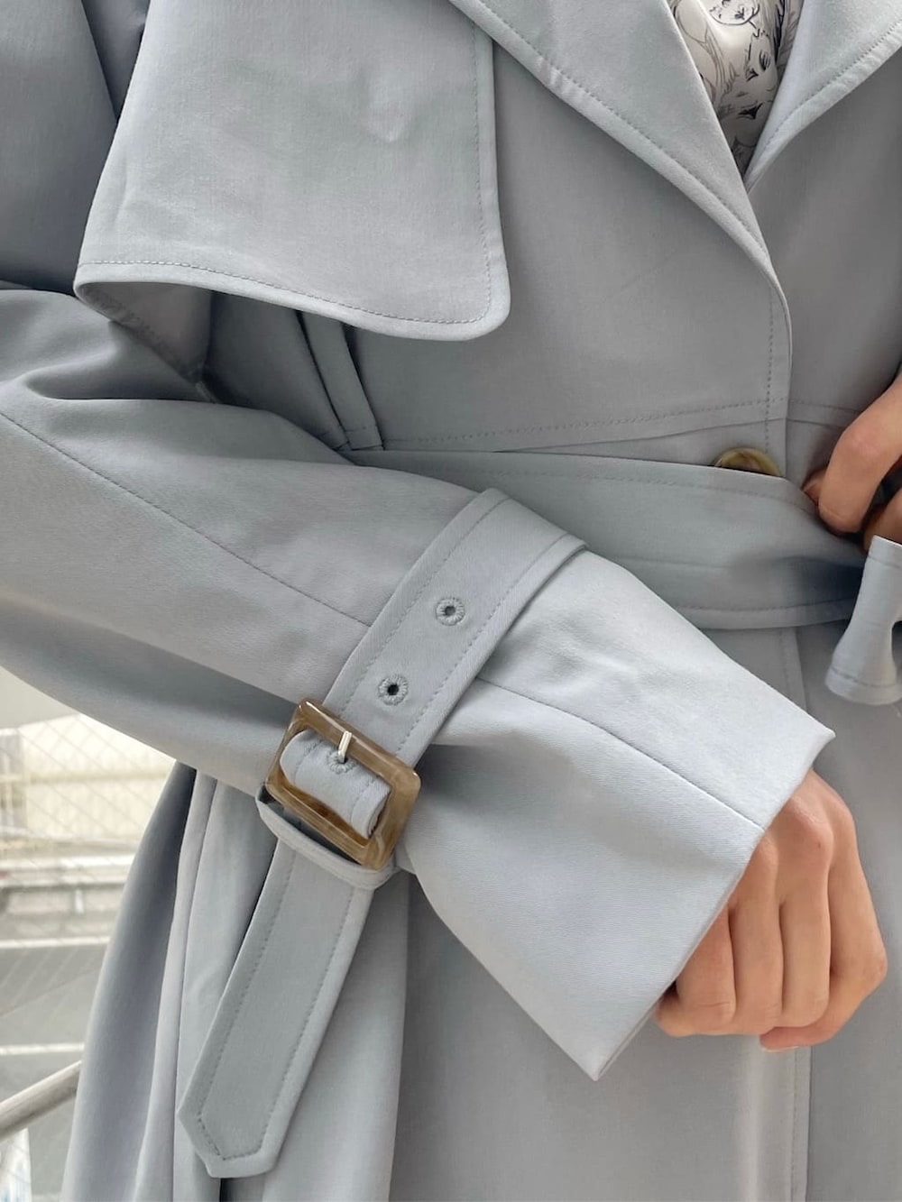 ブルー系のトレンチコート、グレー系のワンピース、ブラック系のローファーを着用したレディースの冬コーディネートの10枚目の写真