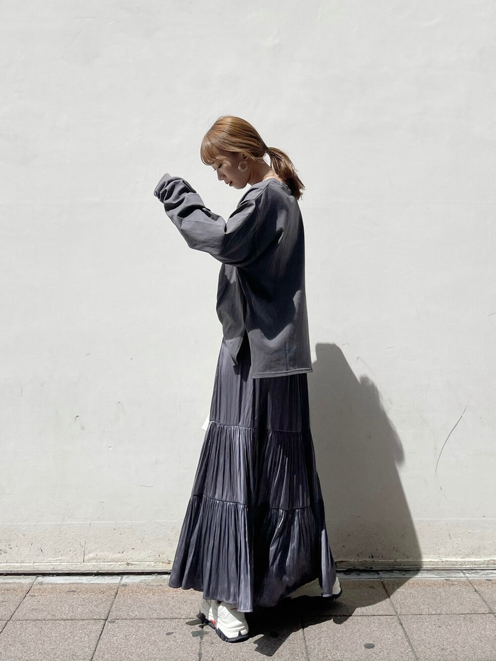 パープル系のスカート、ホワイト系のスニーカー、ホワイト系のハンドバッグを着用したレディースの春コーディネートの4枚目の写真