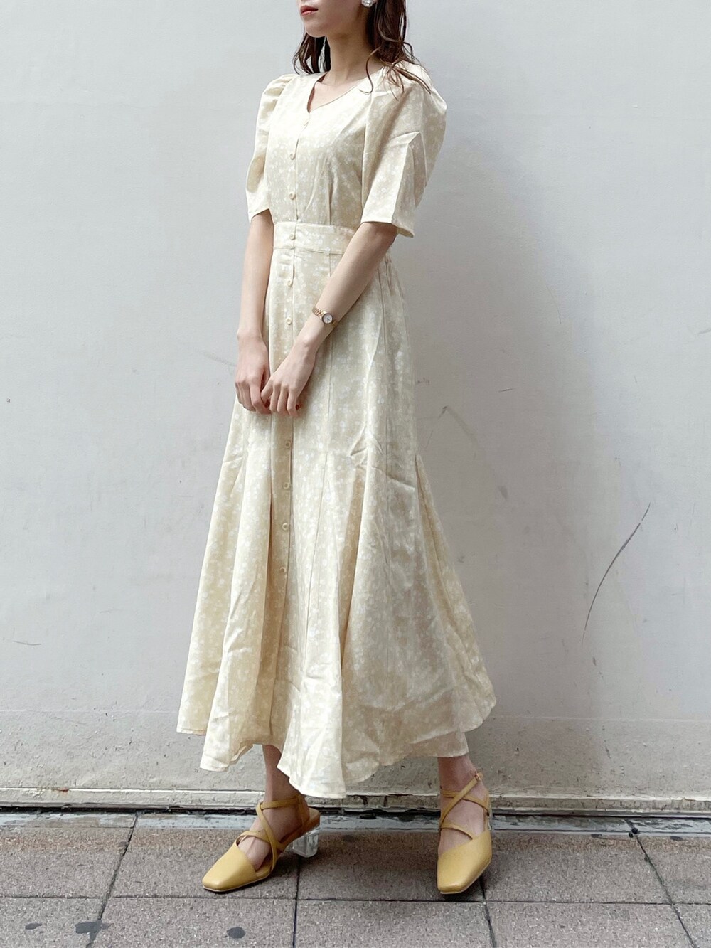 ベージュ系のテーラードジャケット、イエロー系のワンピース、イエロー系のパンプスを着用したレディースの春コーディネートの5枚目の写真