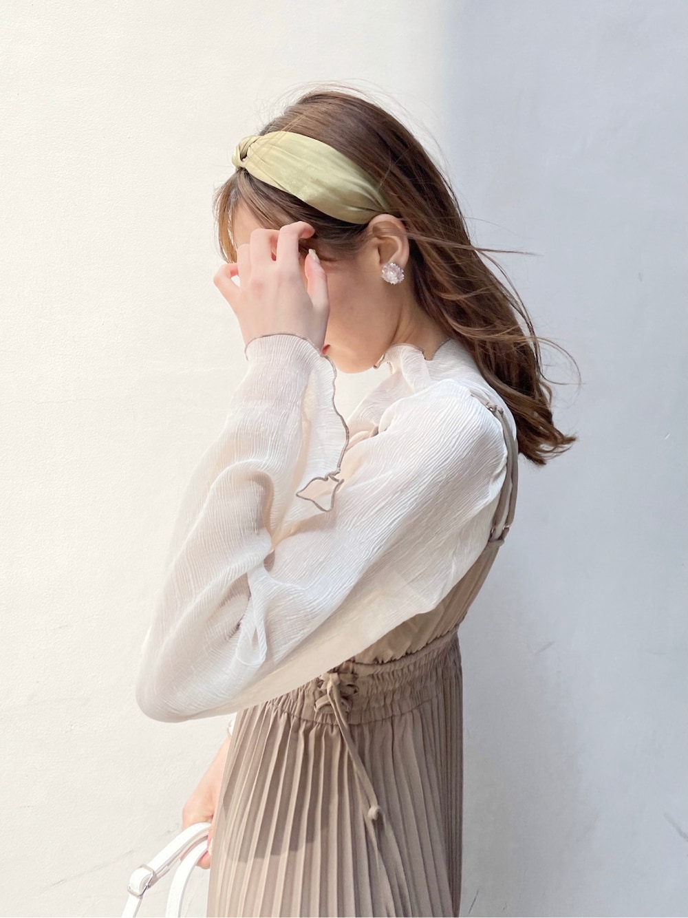 ベージュ系のワンピース、ベージュ系のTシャツ/カットソー、ホワイト系のパンプスを着用したレディースの春コーディネートの3枚目の写真