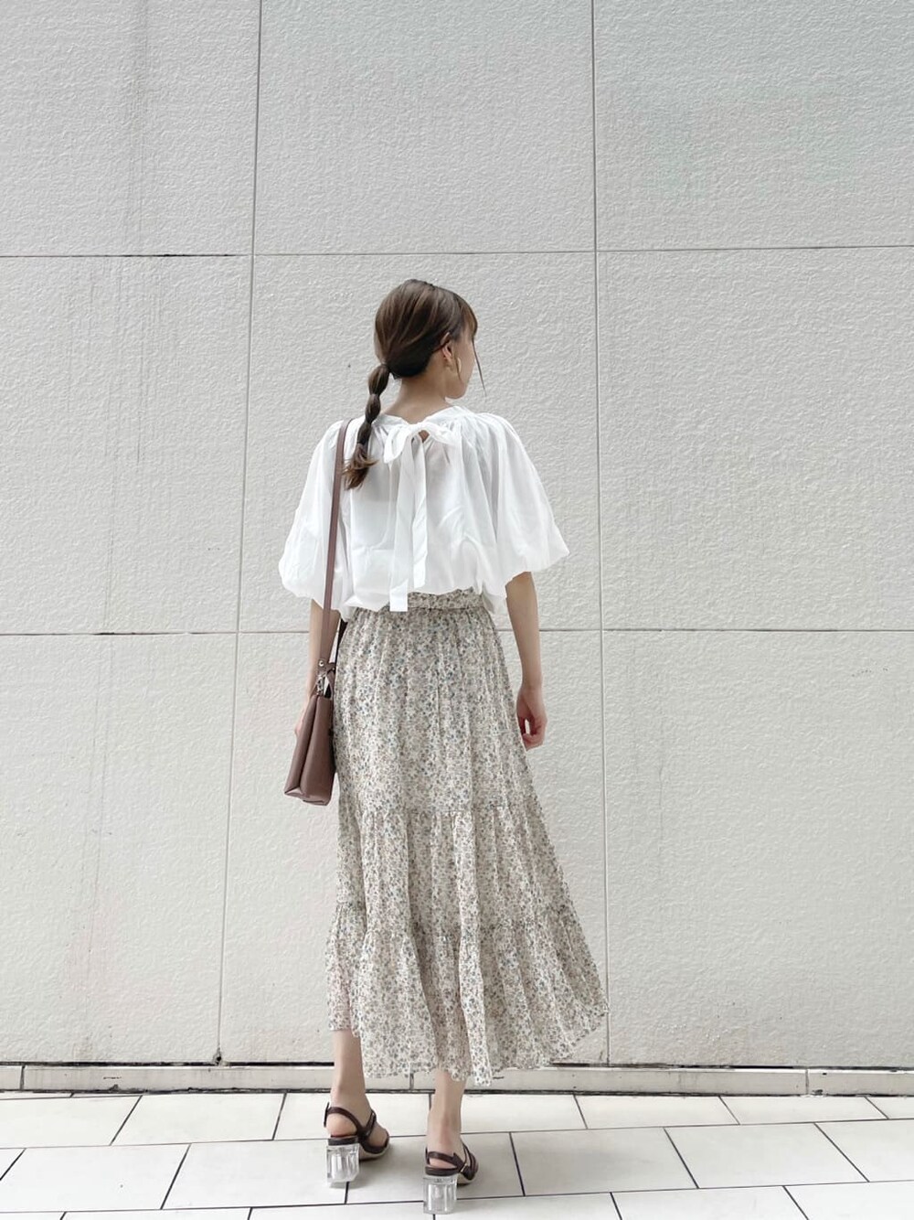 ブラウン系のハンドバッグ、ブラウン系のサンダル、ホワイト系のシャツ/ブラウスを着用したレディースの夏コーディネートの4枚目の写真