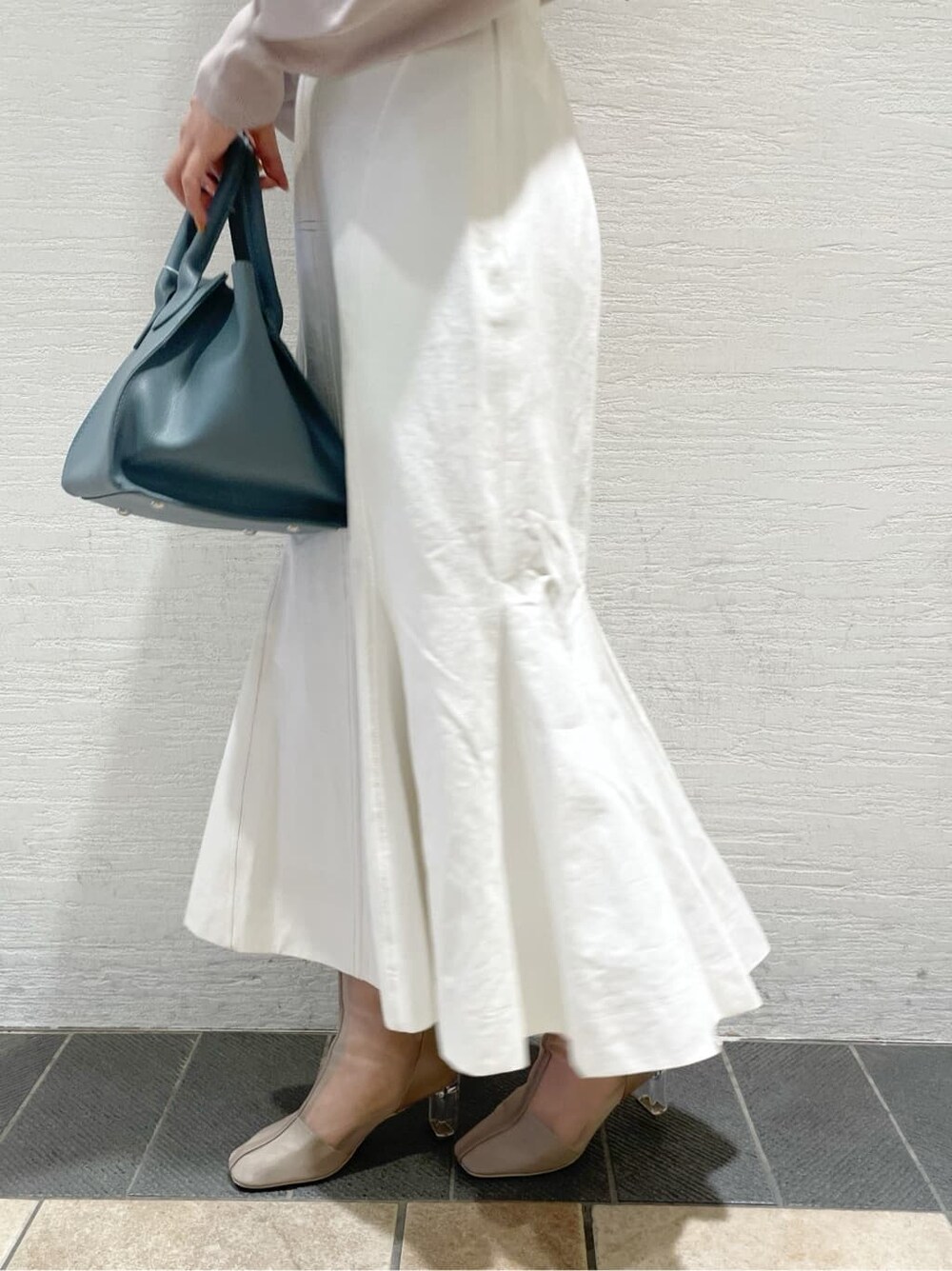 ベージュ系のニット/セーター、ブルー系のハンドバッグ、ベージュ系のブーツを着用したレディースの冬コーディネートの10枚目の写真