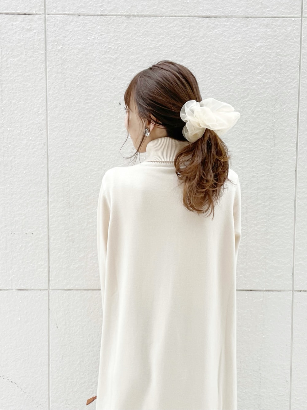 ブルー系のその他パンツ、ブラウン系のクラッチバッグ、ホワイト系のブーツを着用したレディースの冬コーディネートの4枚目の写真