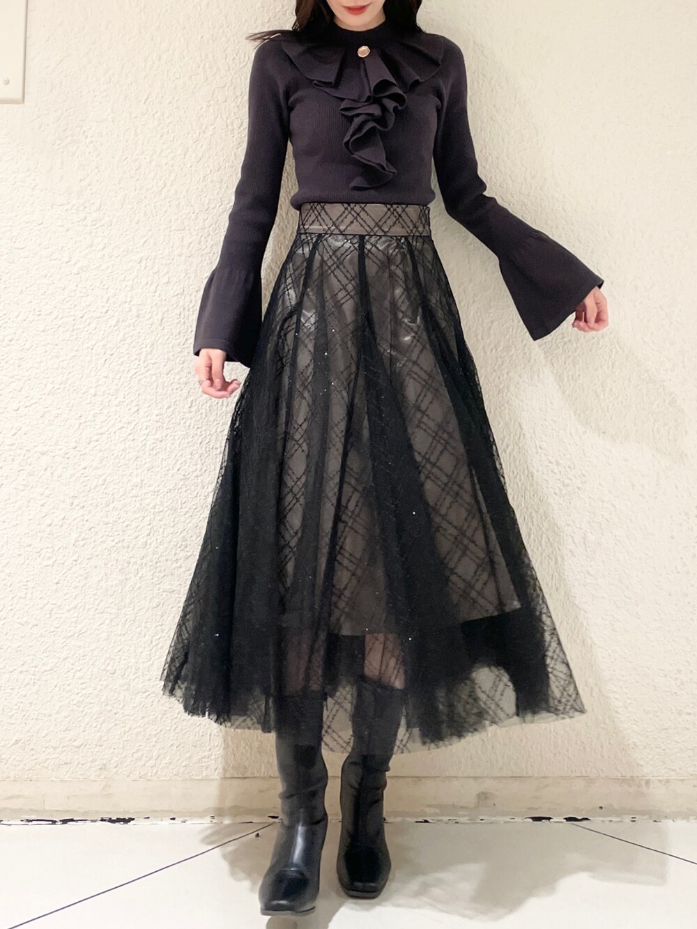 ブラック系のブーツ、ブラック系のニット/セーター、ブラック系のスカートを着用したレディースの冬コーディネートの3枚目の写真