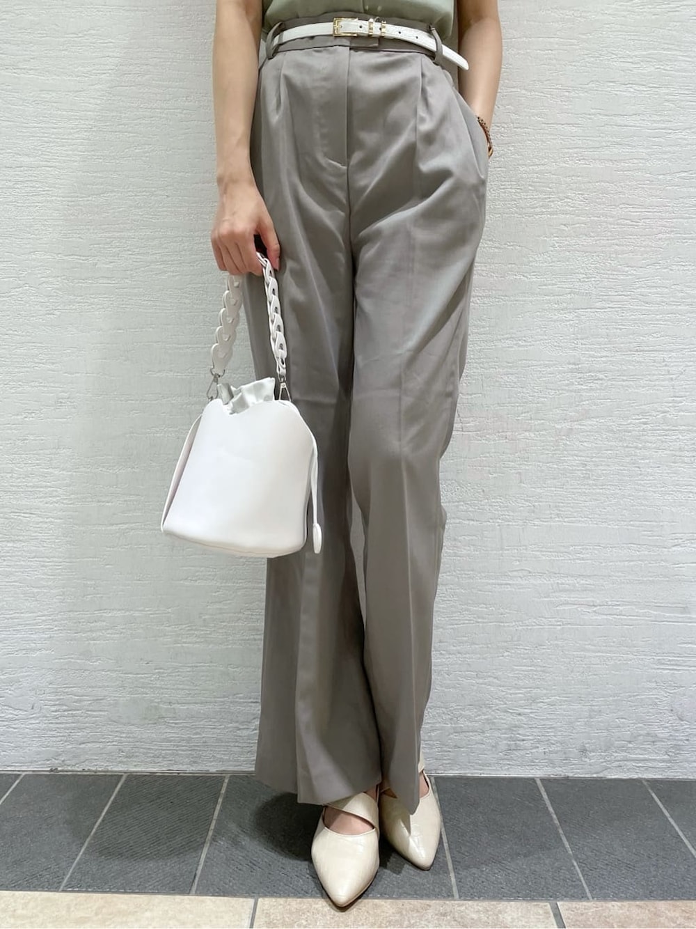 グレー系のその他パンツ、ホワイト系のハンドバッグ、グリーン系のニット/セーターを着用したレディースの夏コーディネートの9枚目の写真