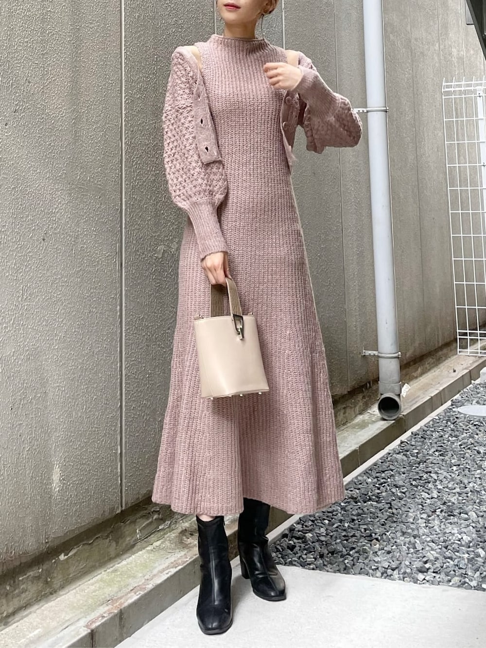 ベージュ系のワンピース、ブラック系のブーツ、ベージュ系のハンドバッグを着用したレディースの秋コーディネートの2枚目の写真