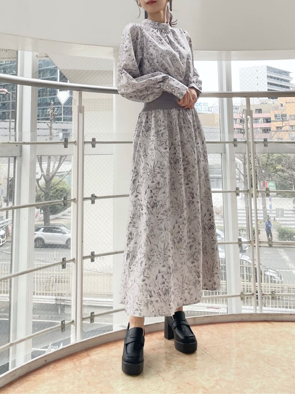 ブルー系のトレンチコート、グレー系のワンピース、ブラック系のローファーを着用したレディースの冬コーディネートの3枚目の写真