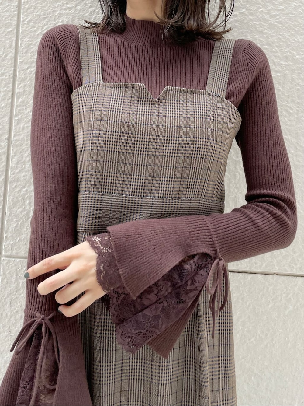 ベージュ系のライダースジャケット、ブラック系のブーツ、その他のジャンパースカートを着用したレディースの秋コーディネートの8枚目の写真