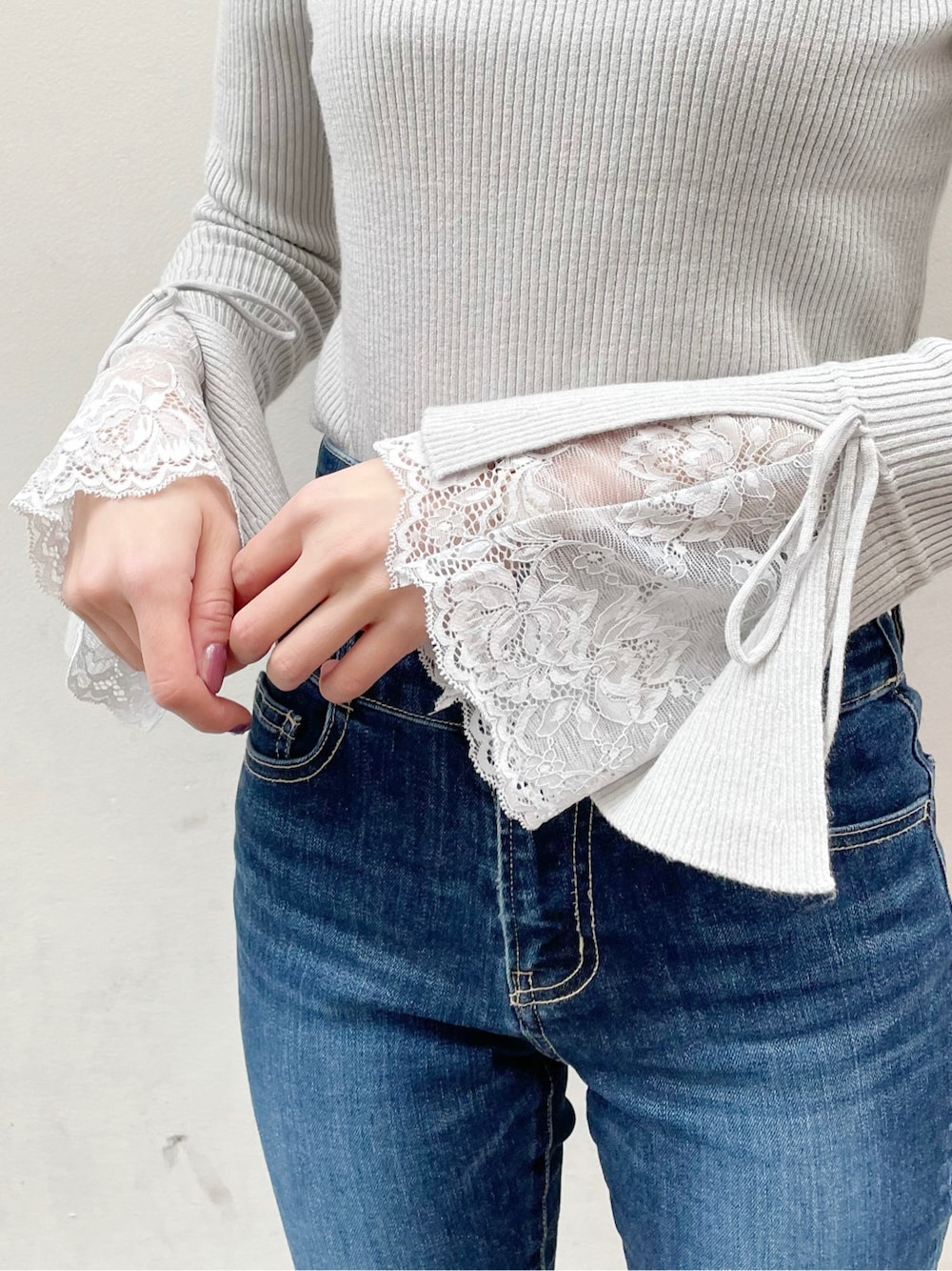 ブルー系のデニムパンツ、ブラック系のブーツ、グレー系のニット/セーターを着用したレディースの冬コーディネートの3枚目の写真