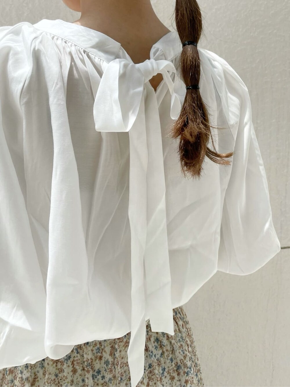 ブラウン系のハンドバッグ、ブラウン系のサンダル、ホワイト系のシャツ/ブラウスを着用したレディースの夏コーディネートの9枚目の写真