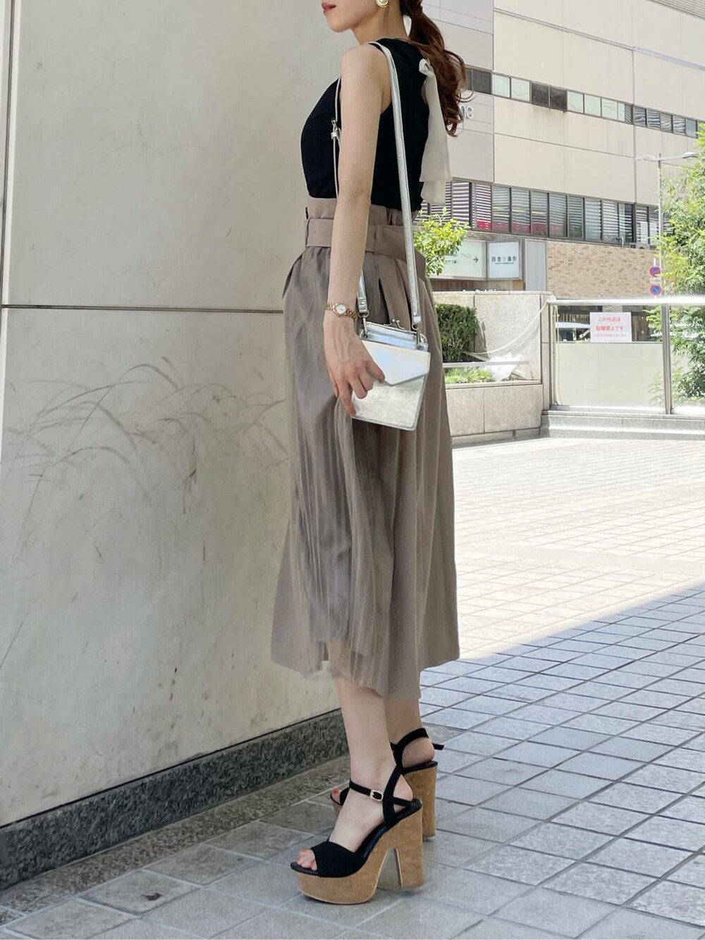 ブラック系のサンダル、ブラック系のTシャツ/カットソー、ベージュ系のスカートを着用したレディースの夏コーディネートの3枚目の写真