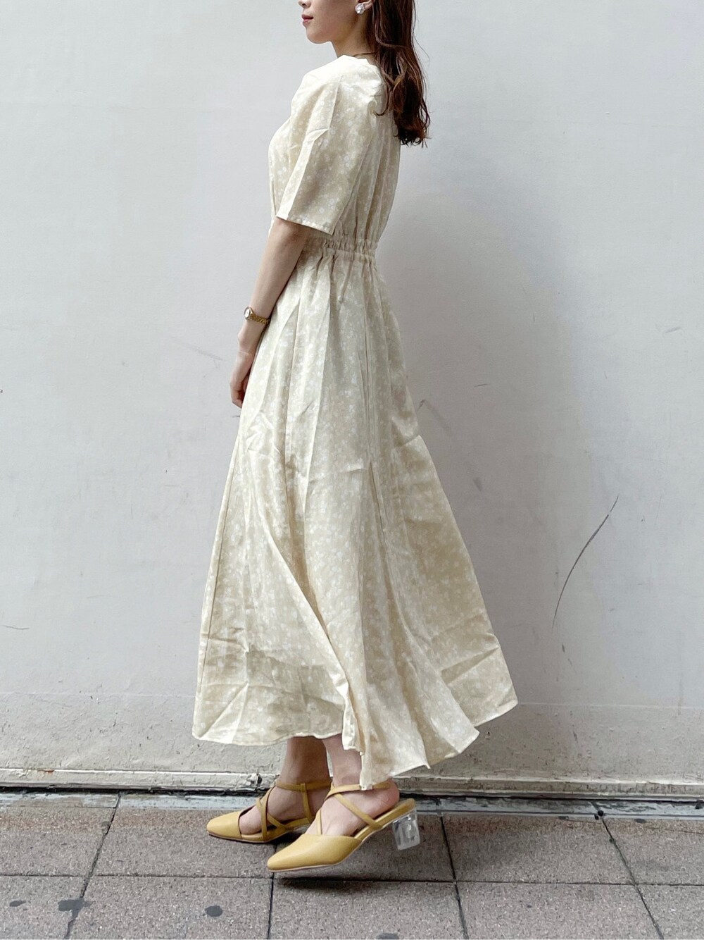 ベージュ系のテーラードジャケット、イエロー系のワンピース、イエロー系のパンプスを着用したレディースの春コーディネートの6枚目の写真