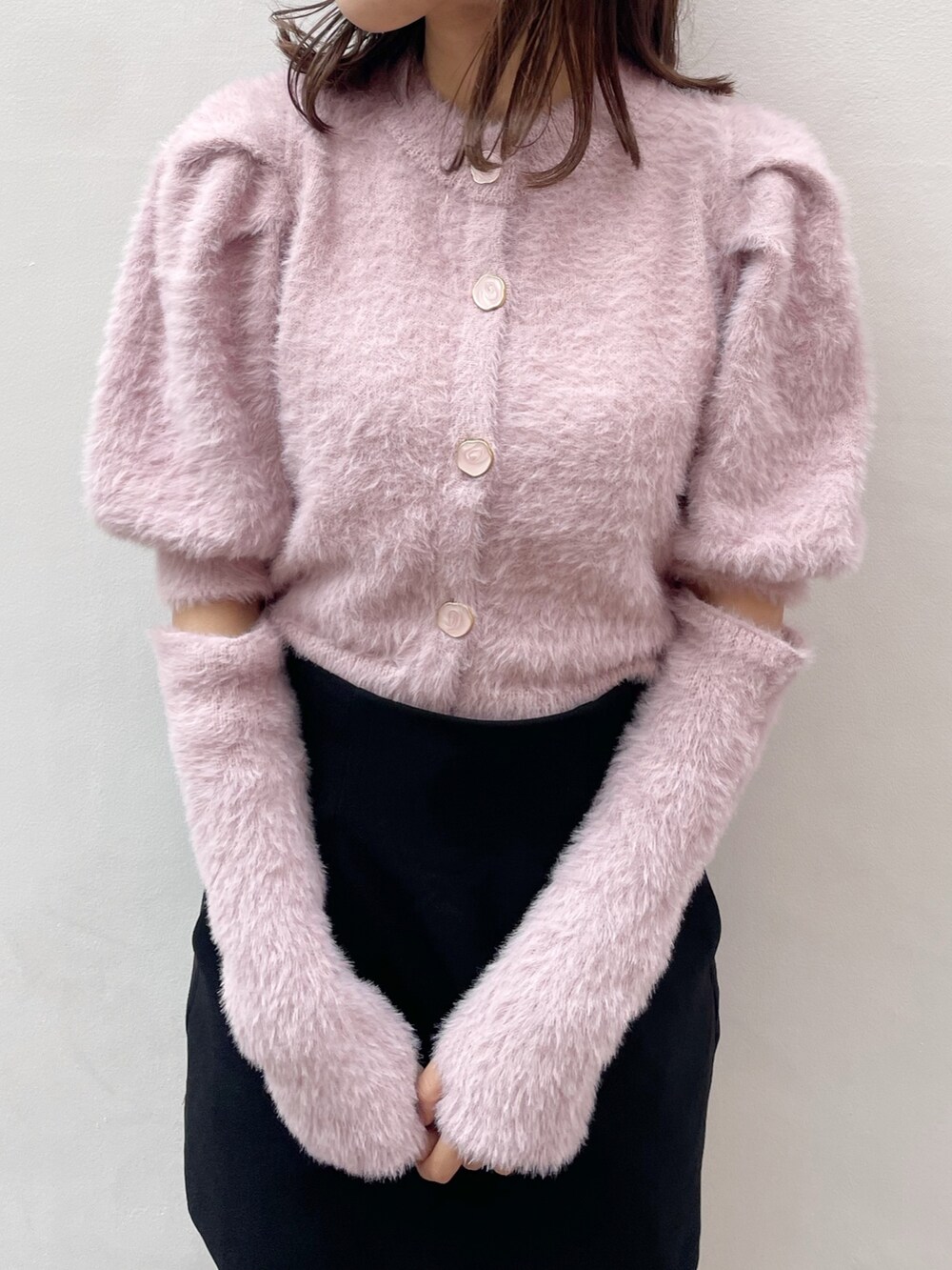 ピンク系のニット/セーター、ブラック系のスカート、ブラック系のブーツを着用したレディースの冬コーディネートの4枚目の写真